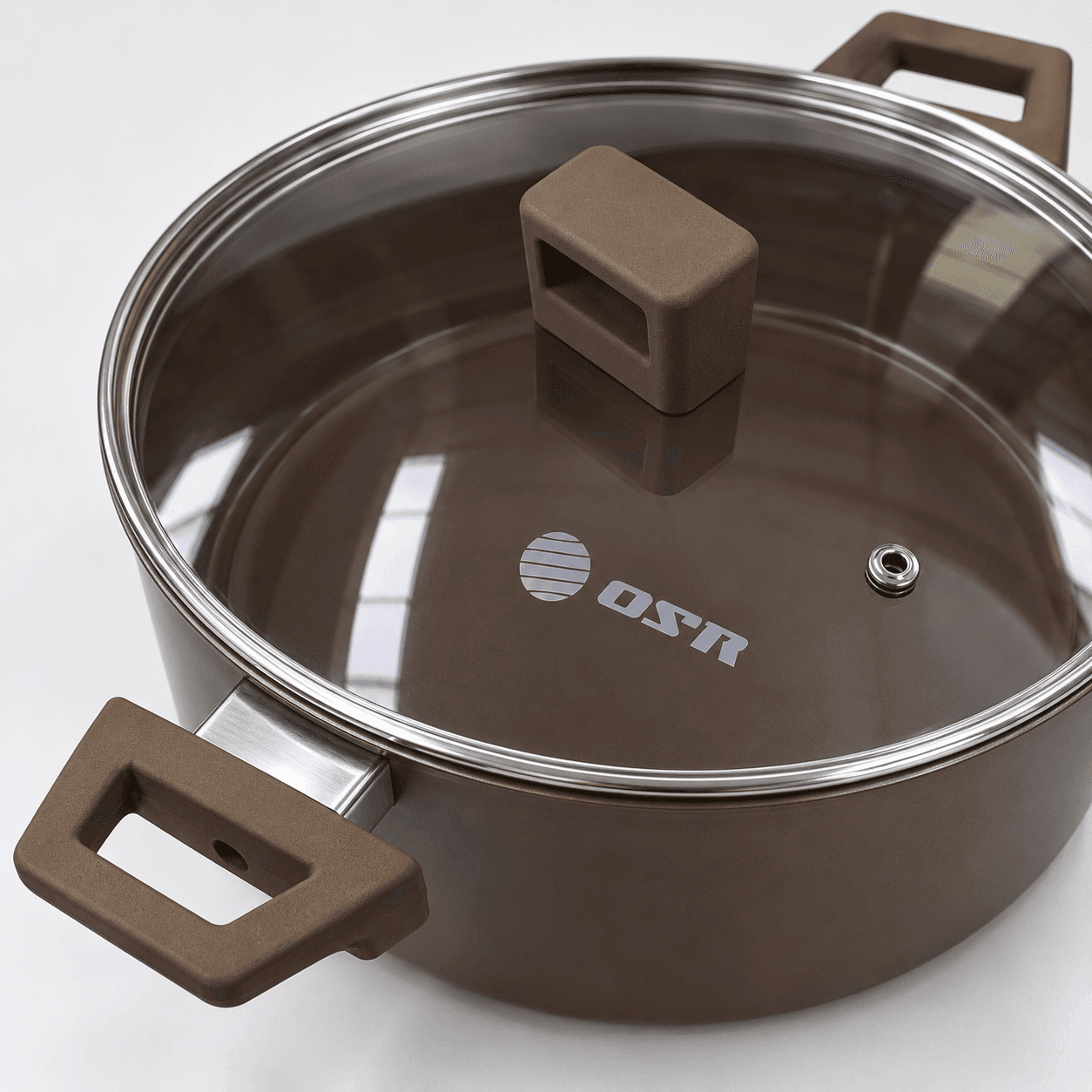 Detalle de olla OSR: tapa transparente, pomo, borde y asa marrón.