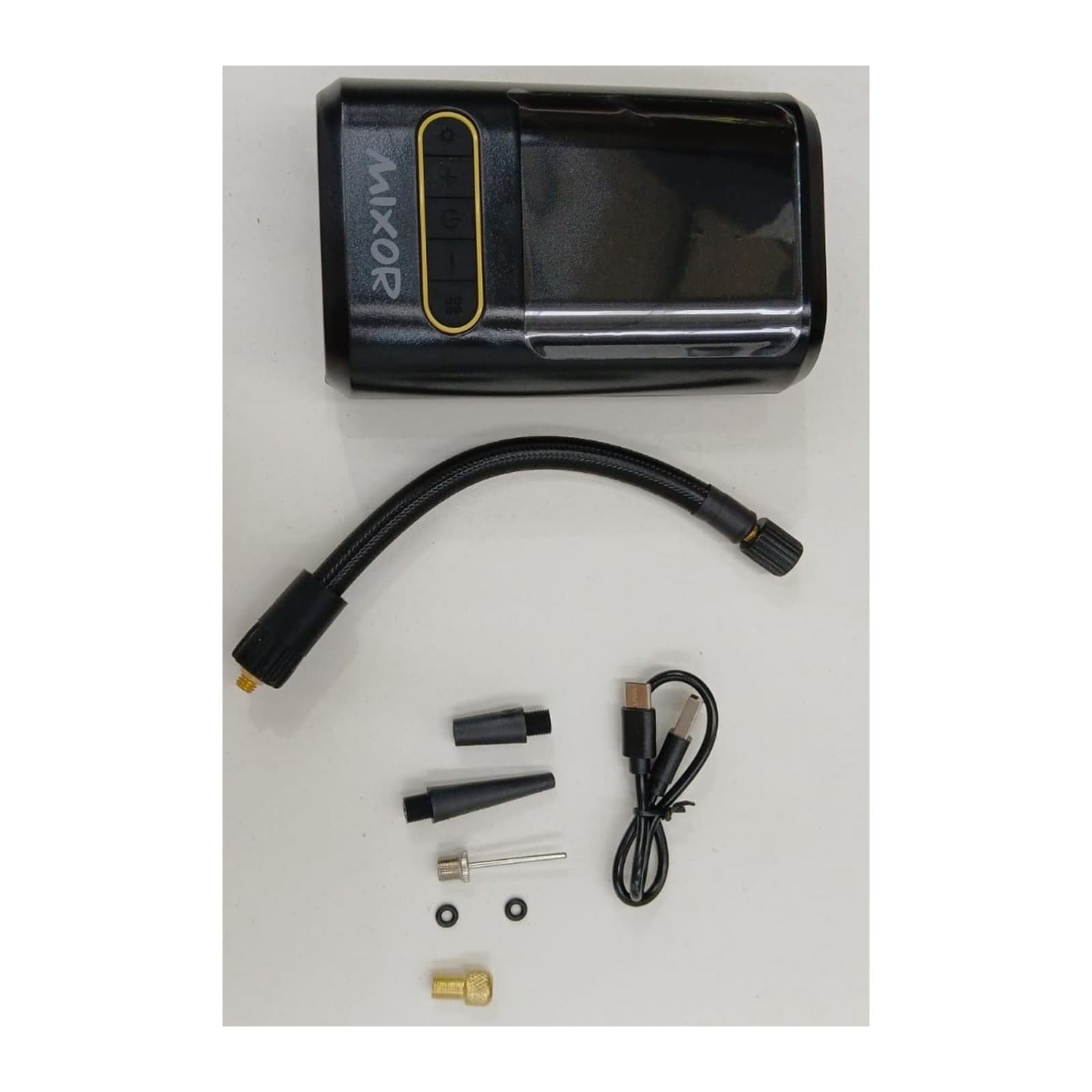 Inflador Mixor Ruta con su manguera flexible, picos, aguja, adaptador dorado, arandelas y cable USB-C, todo sobre una mesa, COMPEXXTNEG — miniatura 3