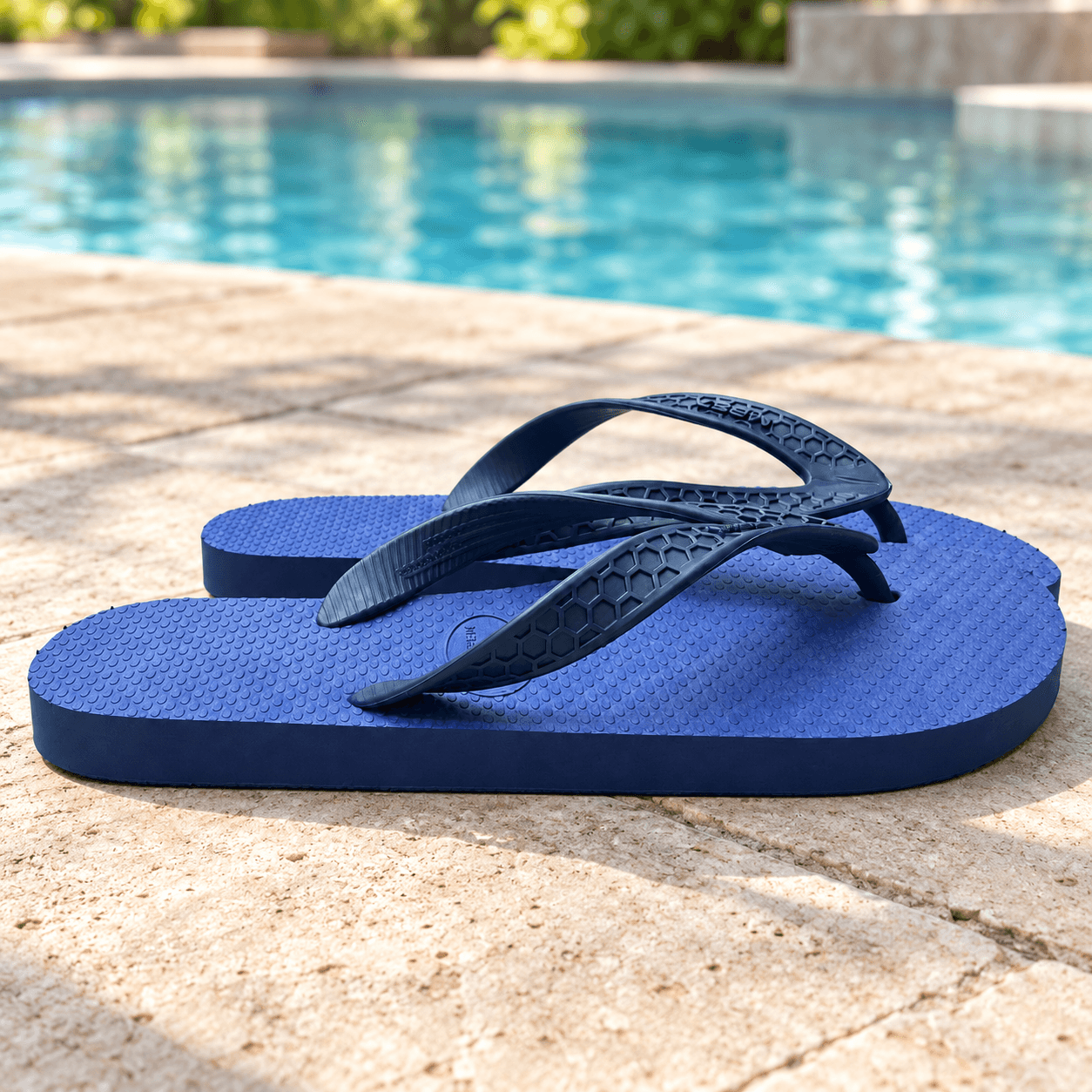 Sandalias de hombre azules sobre una terraza seca junto a una pileta.