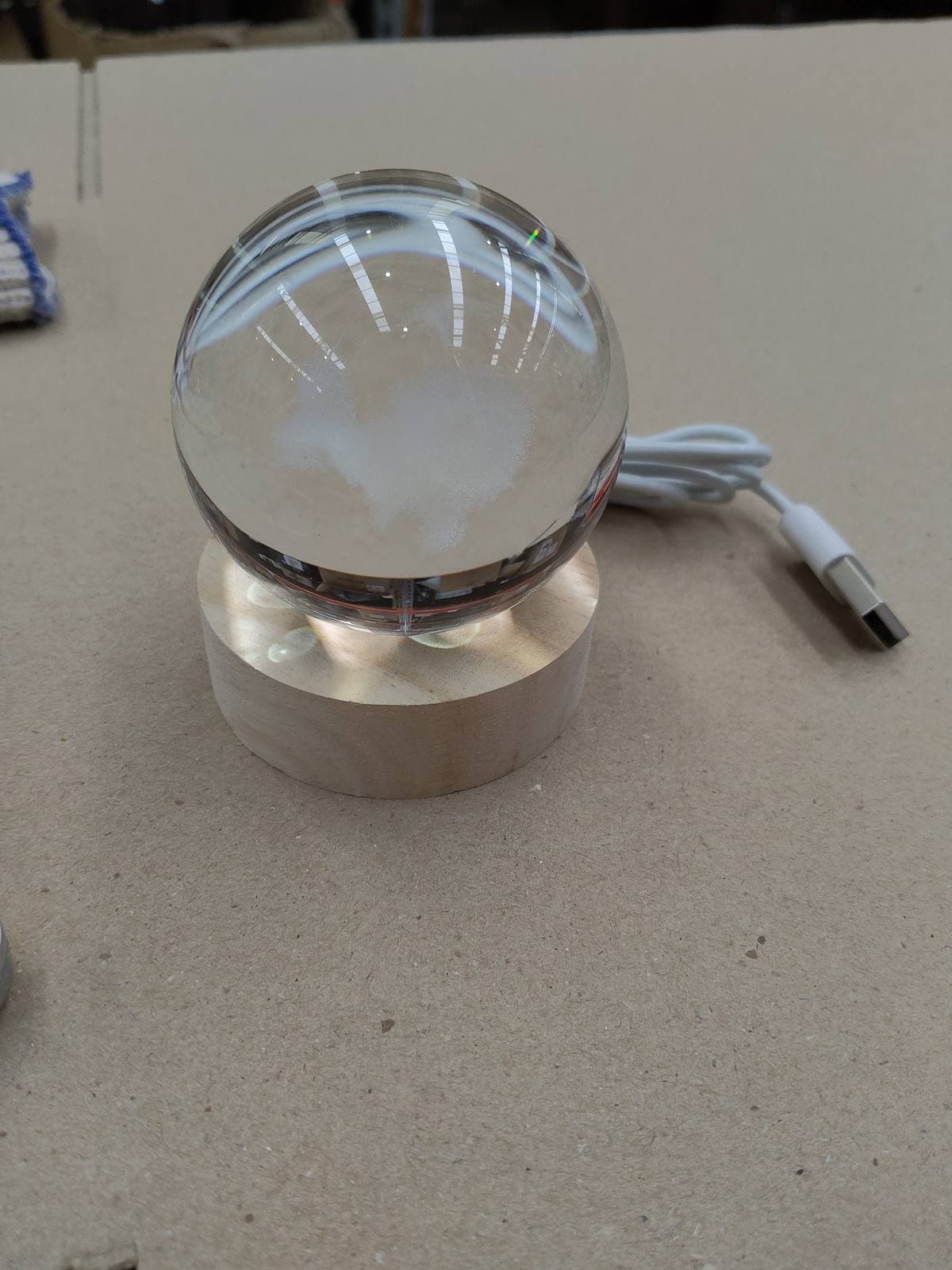 Foto real de la esfera de cristal con la ballena grabada sobre su base de madera y el cable USB — miniatura 7