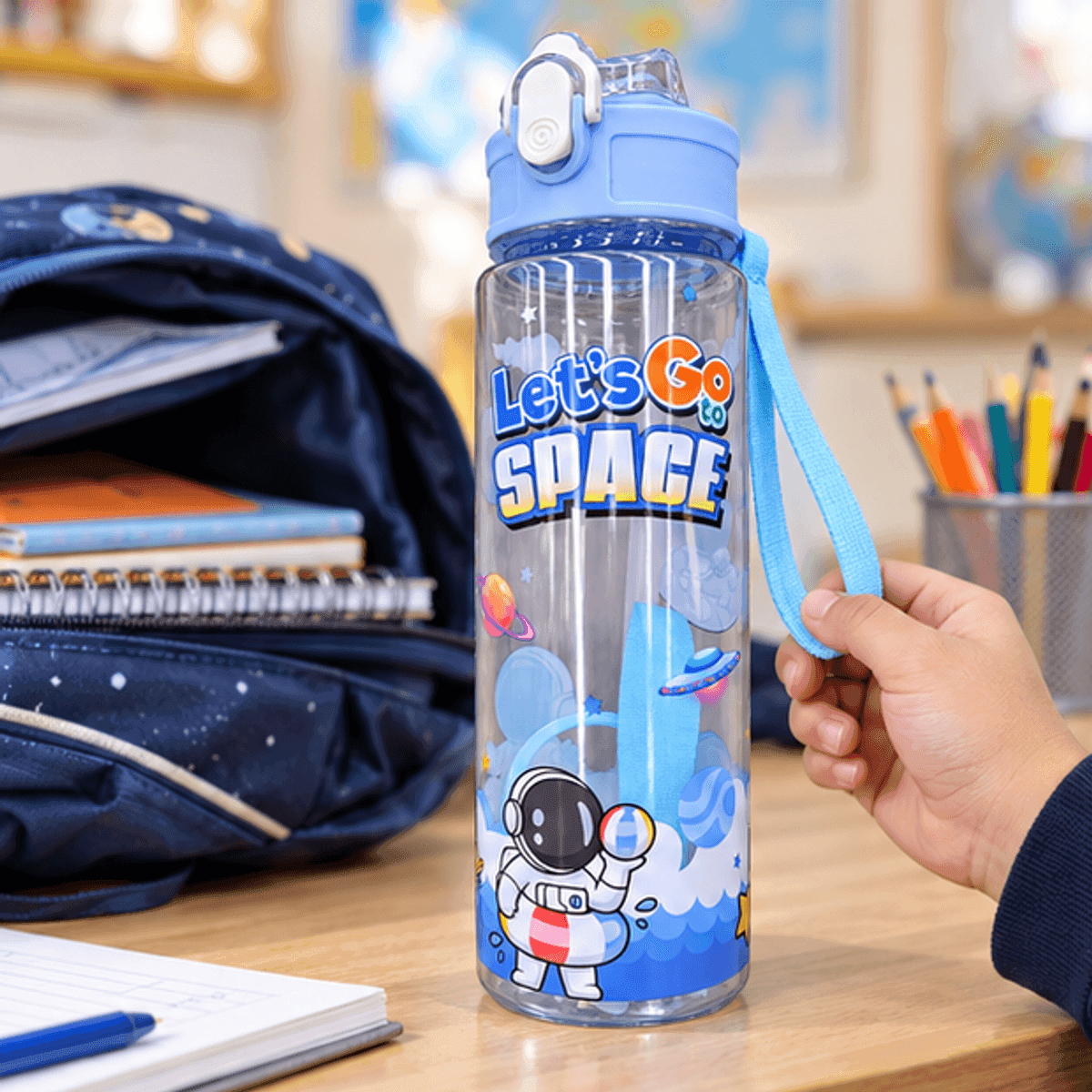 HANDOFF-48|BOTNIÑPLAST|02|bf78e52ca357|Botella Infantil 750 ml con Sorbete y Correa - Diseño Espacial - Celeste - Producto en contexto de uso