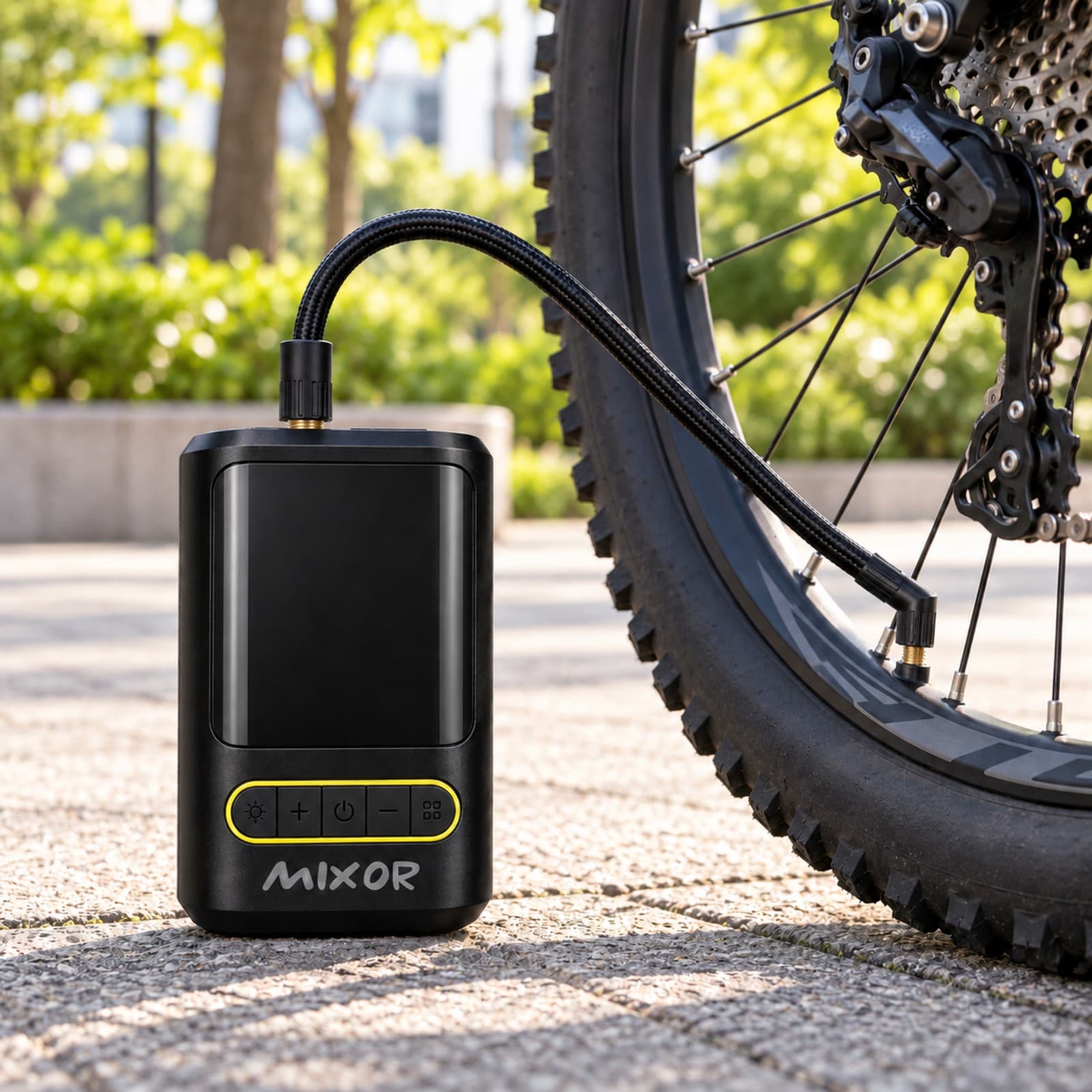 Inflador Mixor Ruta negro con la manguera conectada a la válvula de la rueda de una bicicleta de montaña en una plaza (imagen ilustrativa), COMPEXXTNEG — miniatura 6