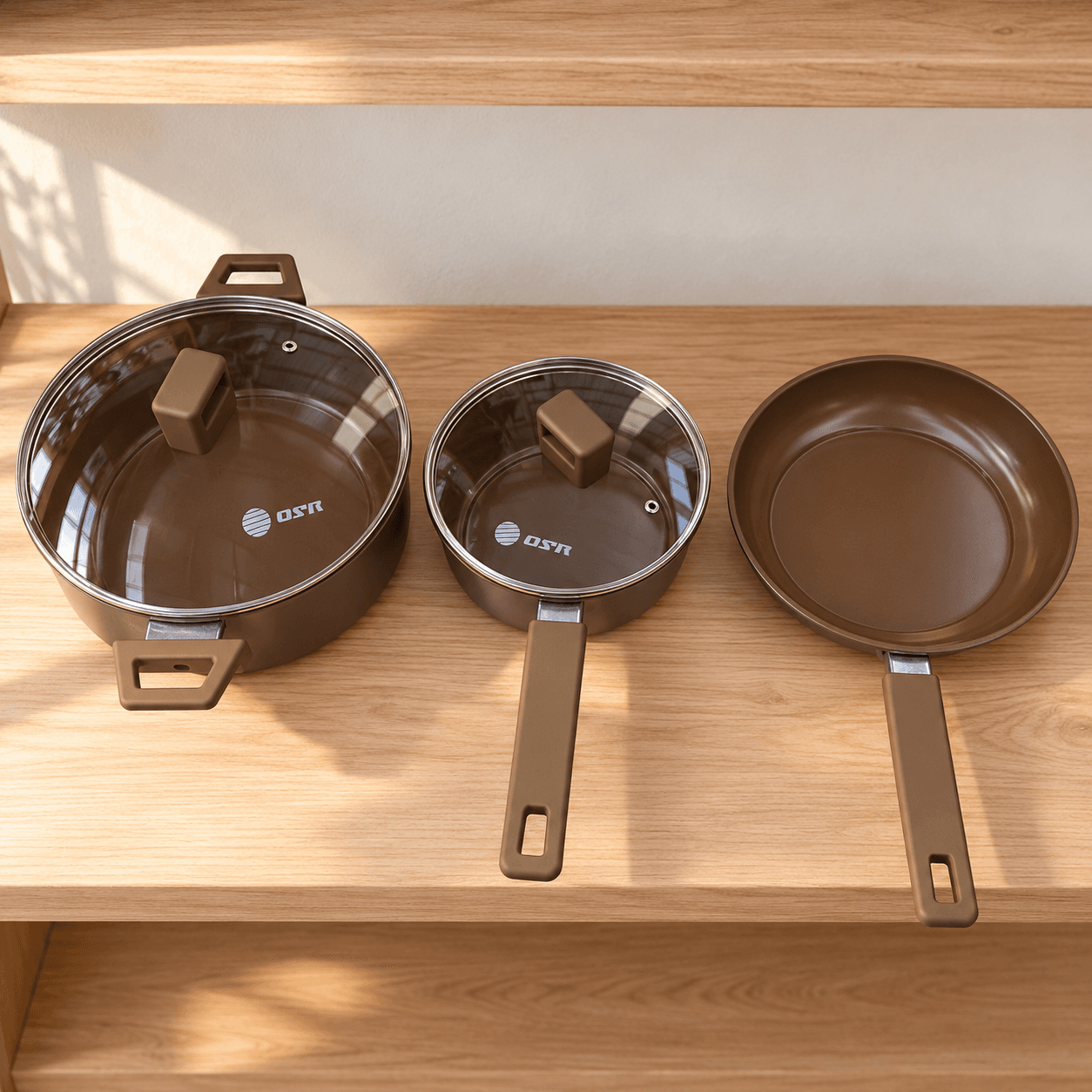 Olla, cacerola y sartén OSR presentadas por separado en un estante de cocina.