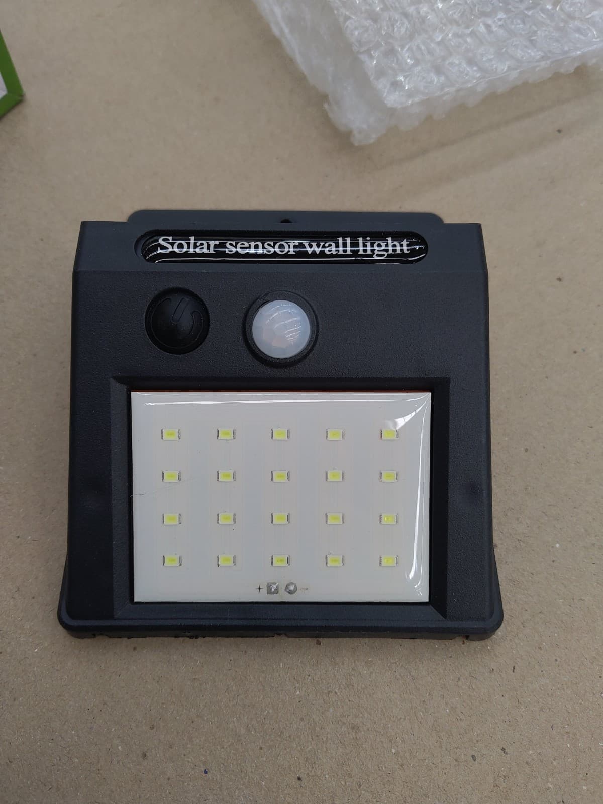 Reflector solar con 20 luces LED, foto real del depósito: frente con el panel de LED, el botón y el sensor de movimiento — miniatura 5